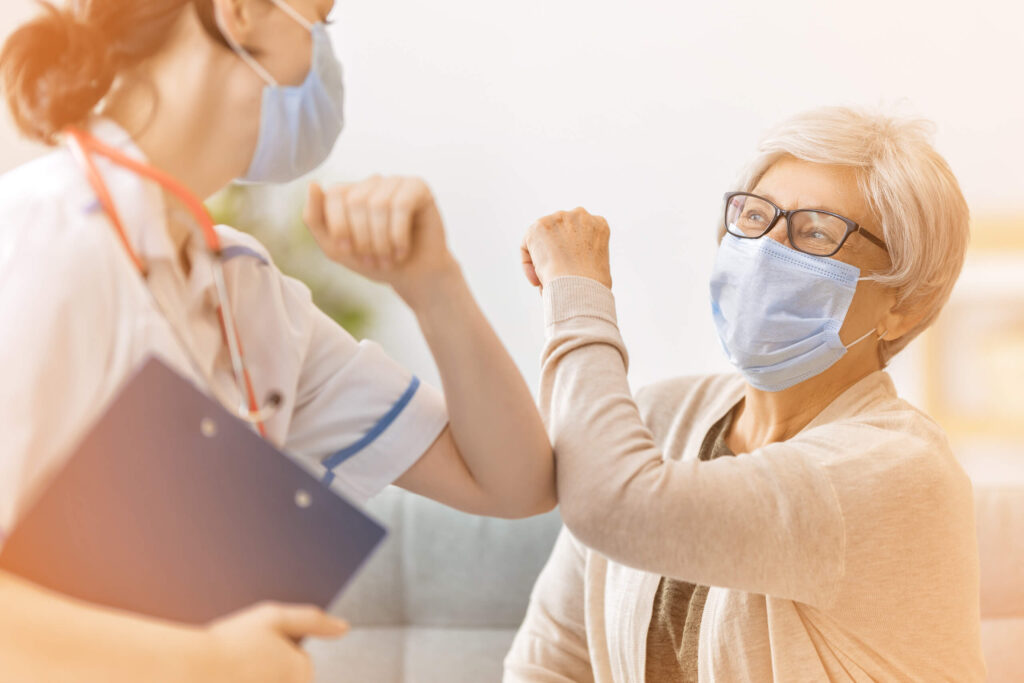 2 Personen geben sich einen Corona Handshake